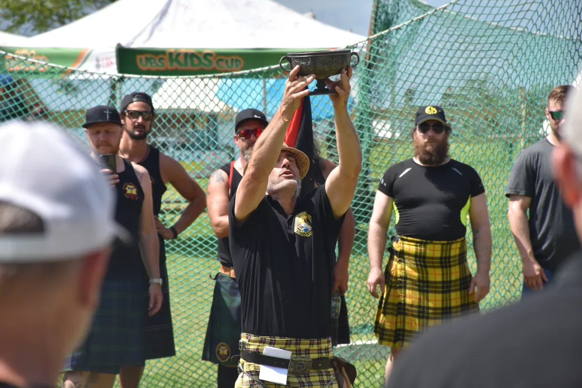 Ein Mann streckt einen Kelch in die Höhe.